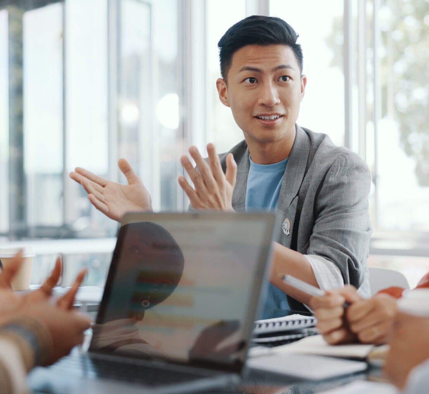 A man discusses document legalization during a meeting with colleagues in a bright, modern office.