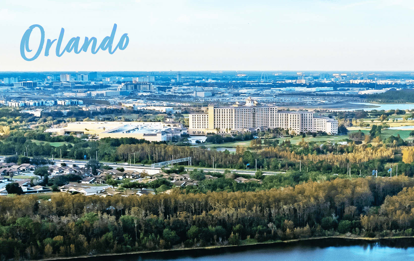 Aerial view of Orlando, Florida, with a large hotel surrounded by greenery and suburban homes near a lake—perfect for hosting events like the Legal Week Conference. The city skyline is visible in the distance, and "Orlando" appears in blue across the sky.